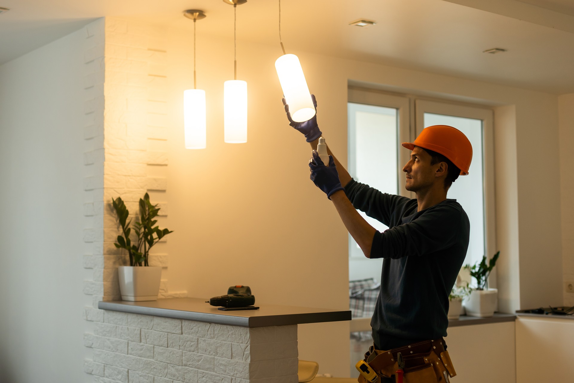 Electrician installs lamp lighting and spot loft style